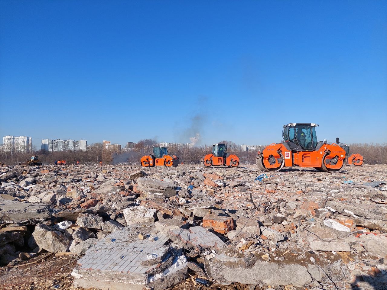 Техника выравнивает рельеф, засыпая слой строительного мусора, в том числе крупные обломки снесенных по реновации домов